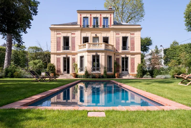 Long bassin miroir face à une demeure ancienne en pierre et brique, grande pelouse, arbres adultes, reflet de la façade dans l'eau — projet complet eau et jardin Aqua System, ouest parisien