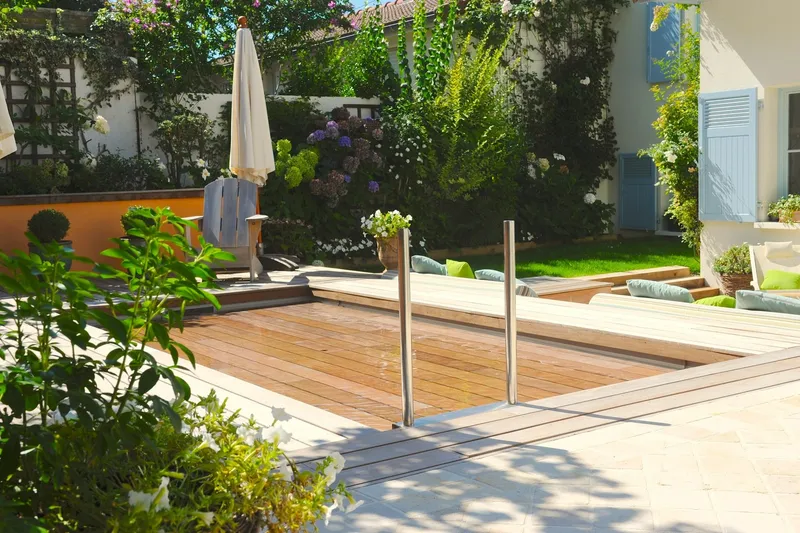 Piscine à fond mobile avec platelage bois affleurant, fond remonté formant une terrasse praticable — réalisation Aqua System, ouest parisien